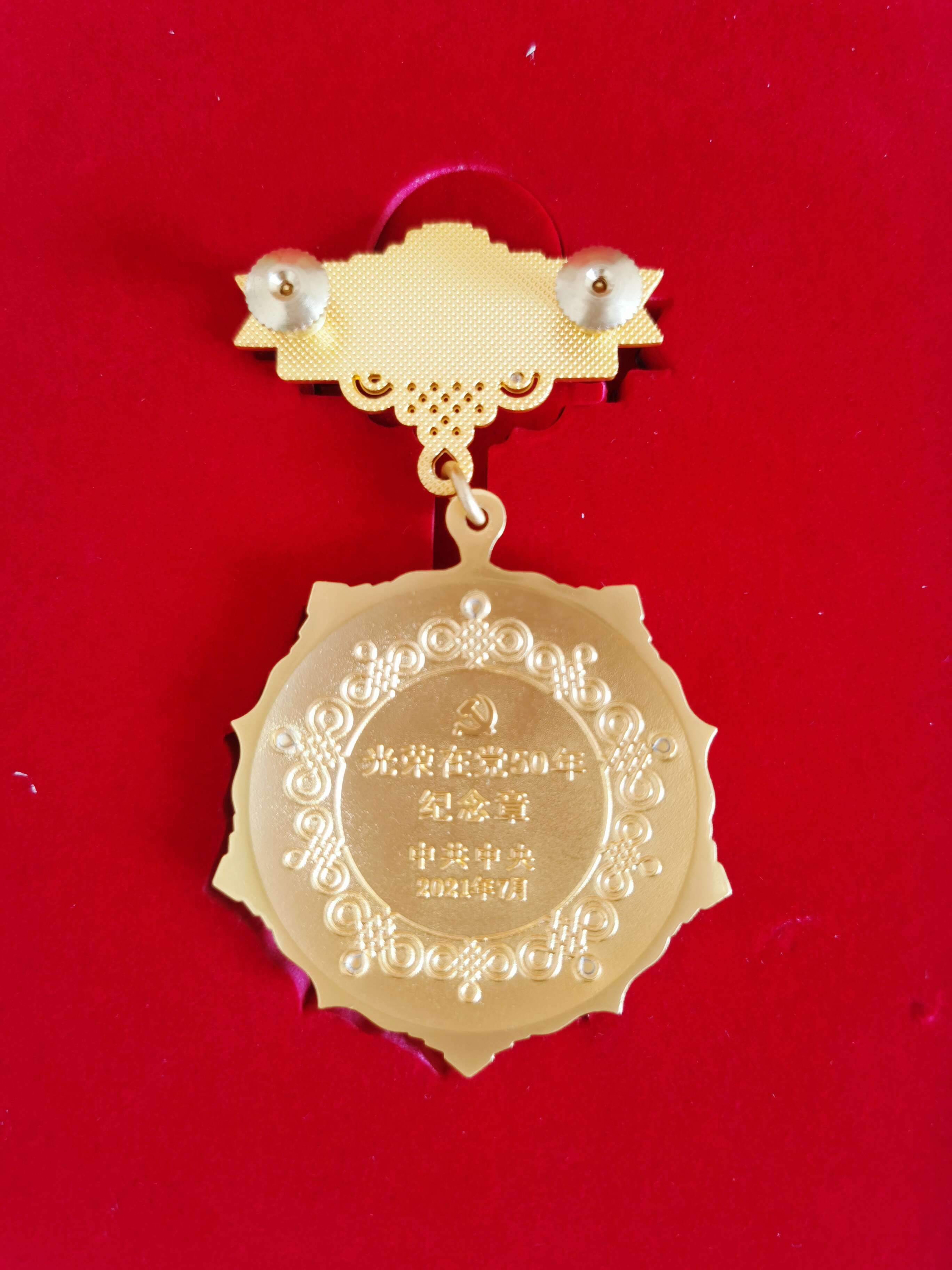 光榮在黨50年紀念獎章背面。  閆慧/攝